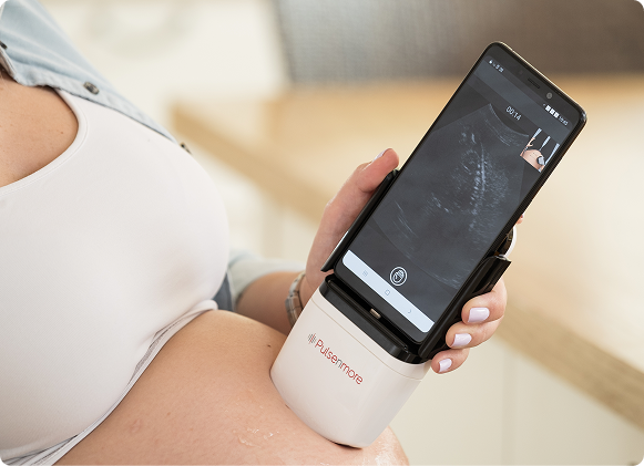 woman holding a Pulsenmore home ultrasound  device  scanning her belly attached, blurred background